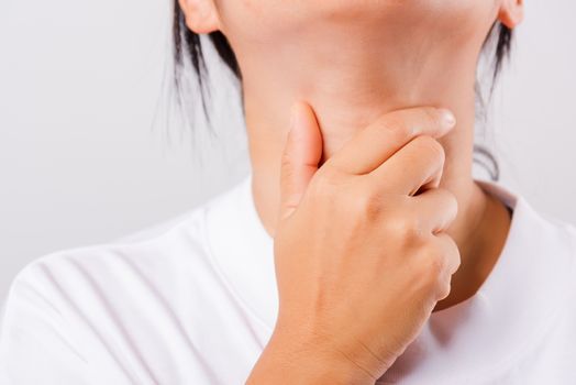 Asian beautiful woman Sore Throat or thyroid gland problem her useing Hand Touching Ill Neck on white background with copy space, Medical and Healthcare concept