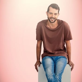 Portrait of smiling male model on seat against pink background 