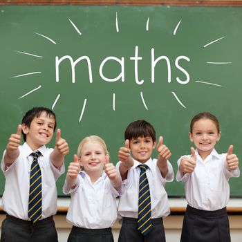 The word maths against cute pupils showing thumbs up in classroom