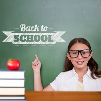 Cute pupil pointing against back to school message