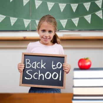 Back to school message against cute pupil showing chalkboard