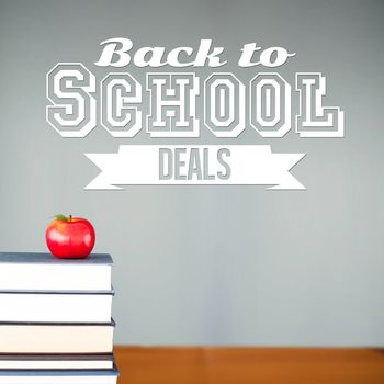 Back to school deals message against red apple on pile of books in classroom