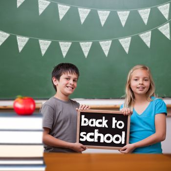 Back to school message against cute pupils showing chalkboard