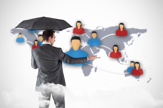 Businessman holding an umbrella with hand out against view of communication network