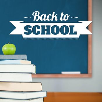 Back to school message against green apple on pile of books in classroom