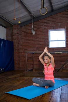 Teenage girl practicing yoga in fitness studio