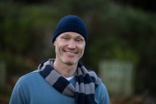Portrait of smiling man in warm clothing standing outdoors
