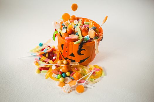 High angle view of orange bucket with various sweet food during Halloween