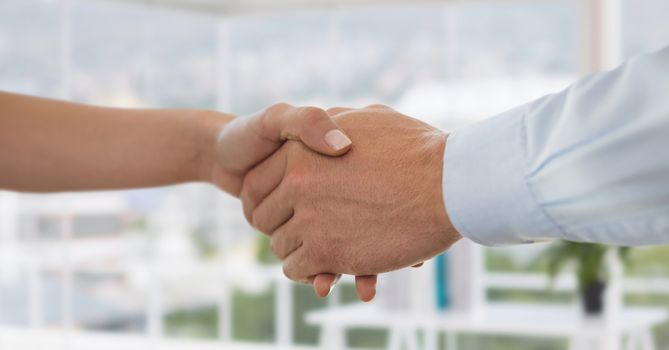 Digital composite of Business people shaking hands against office background