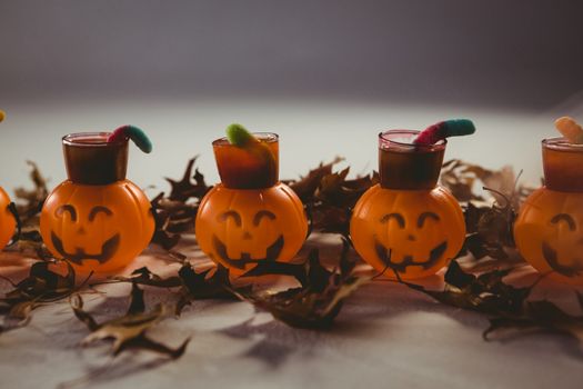 Food in jack o lantern containers with leaves during Halloween over white backgrund