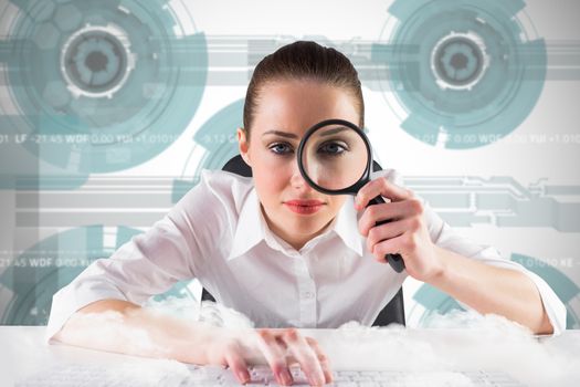 Businesswoman typing and looking through magnifying glass against technology wheel background