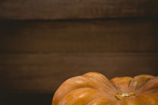 Cropped image of pumpkin against wooden plank during Halloween