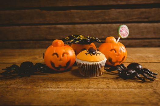 Halloween decorations with cup cake on wooden table