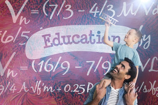 Father carrying son on shoulders against education against blue chalkboard