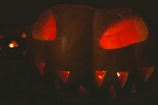 Close up of jack o lantern glowing in darkroom during Halloween