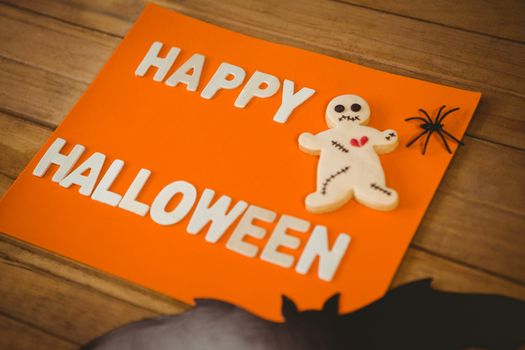 High angle view of happy Halloween text with cookies on orange paper
