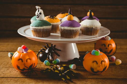 Cup cakes with decorations on wooden table during Halloween