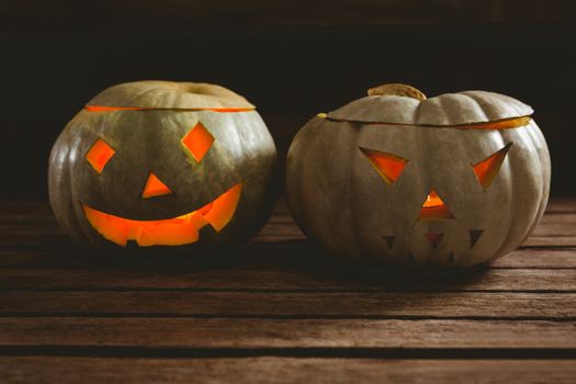 Close up of while illuminated jack o lanterns on table during Halloween