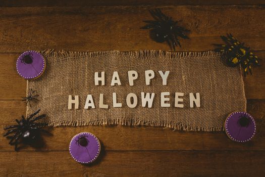 High angle view of happy Halloween text on sack with decorations at table