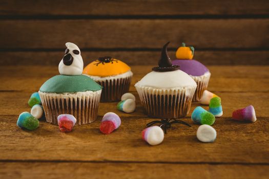 Halloween cup cakes and candies on wooden table