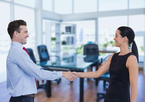 Digital composite of Happy business people shaking hands against office background