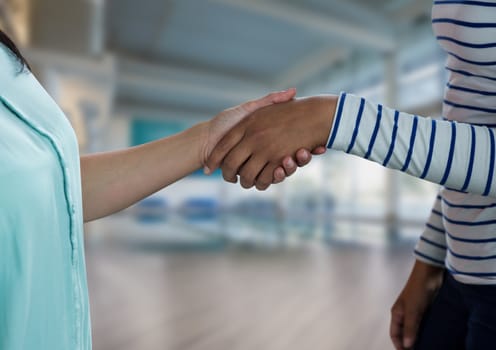 Digital composite of Business people shaking hands against office background