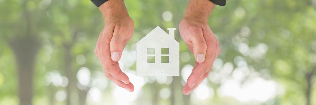 Digital composite of Hands holding a house icon as house insurance concept