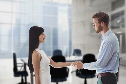 Digital composite of Happy business people shaking hands against office background