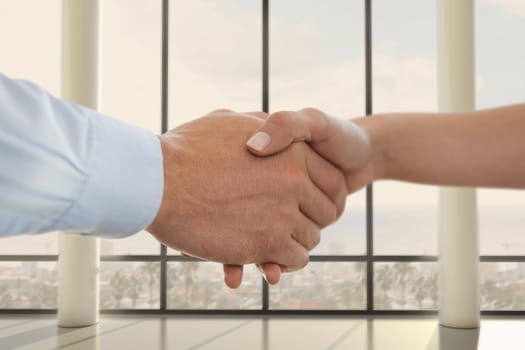 Digital composite of Business people shaking hands against office background