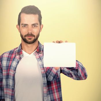 Portrait of young man shoowing placard against light green background 