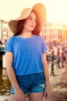 Brunette women wearing summer hat  against canal in amsterdam