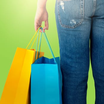 Beautiful brunette women holding bags against green background