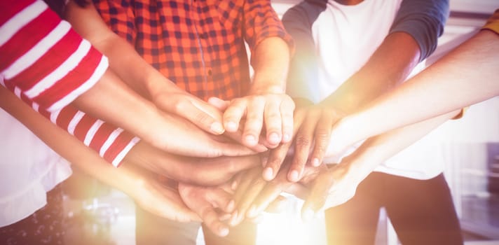 Mid section of business people stacking hands at office