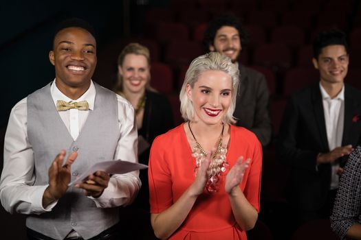 Group of people applauding in movie theatre