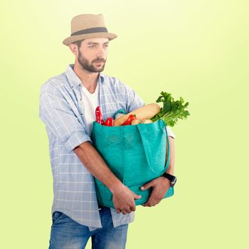 Man carrying vegetables in shopping bag against white background against green background