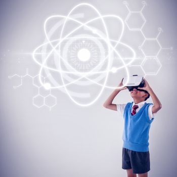 Atomic structure against black background against schoolboy using virtual reality headset