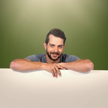 Portrait of smiling young man with cardboard against white background against green background