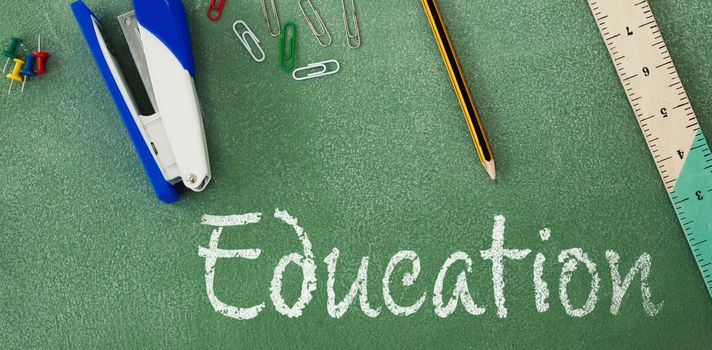 Education text against white background against high angle view of stapler and ruler on table