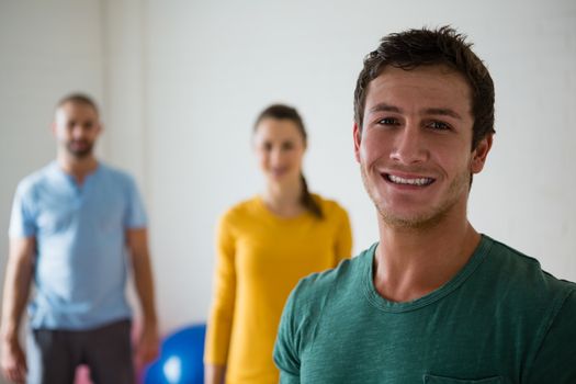 Portrait of man with yoga instructor and woman in health club