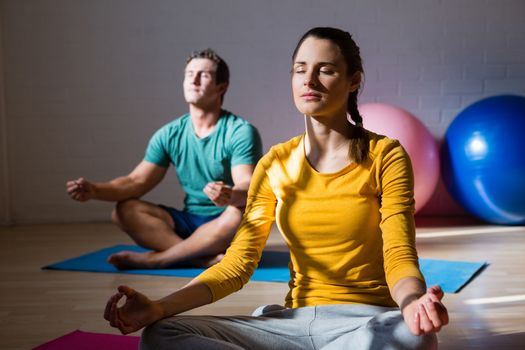 People meditating in lotus position at health club