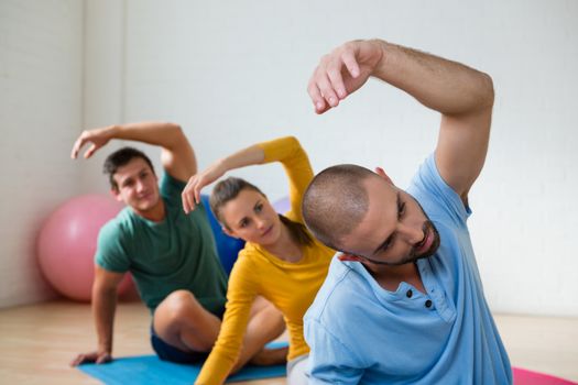 Yoga teacher with student exercising in health club