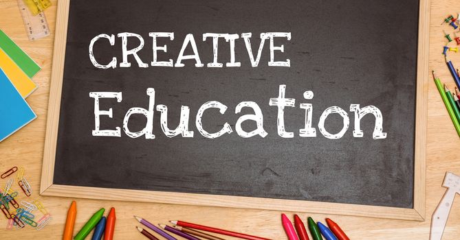 Digital composite of Creative education text on blackboard