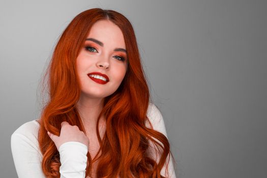 A beauty shot of a young woman with red hair and beauty make-up