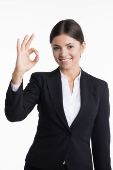 Confident young smiling businesswoman showing OK sign isolated on white background