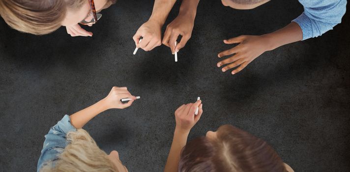 Business people writing with chalks against close-up of blackboard