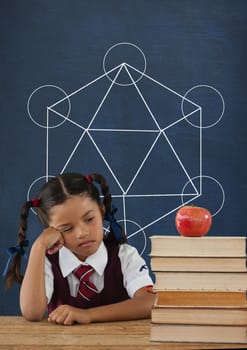 Digital composite of Sad student girl at table against blue blackboard with school and education graphic