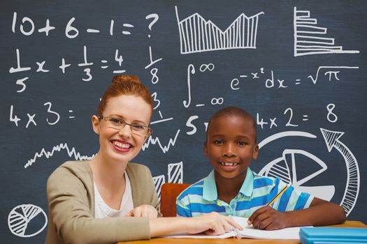 Digital composite of Student boy and teacher at table against blue blackboard with education and school graphics