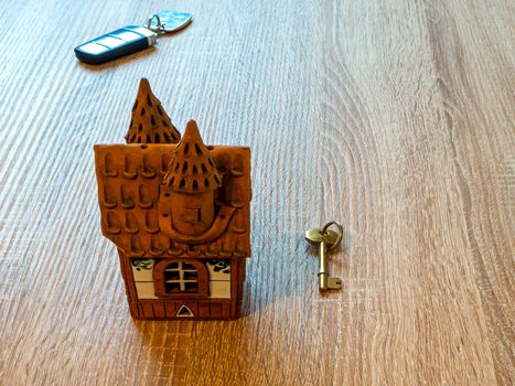 Model of a house and golden key On Wooden Table. Real estate agency, mortgage loan, lottery, buying property.Home loan and investment concept. Copy space