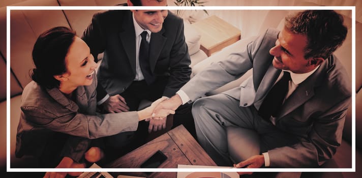 Business people shaking hands while working in cosy meeting room