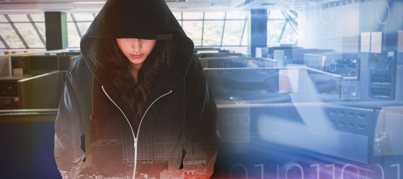 Female hacker in black hoodie against composite image of blue technology design with binary code